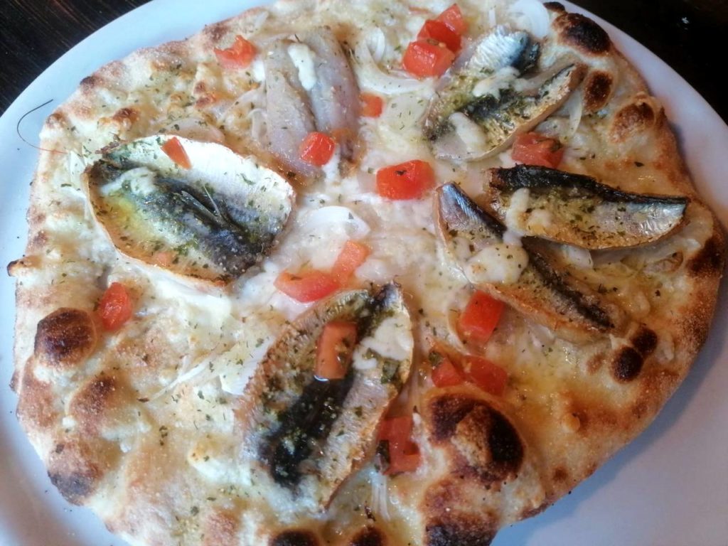 Pizza alici, pomodoro fresco, cipolla, aglio, mozzarella, spezie mediterranee